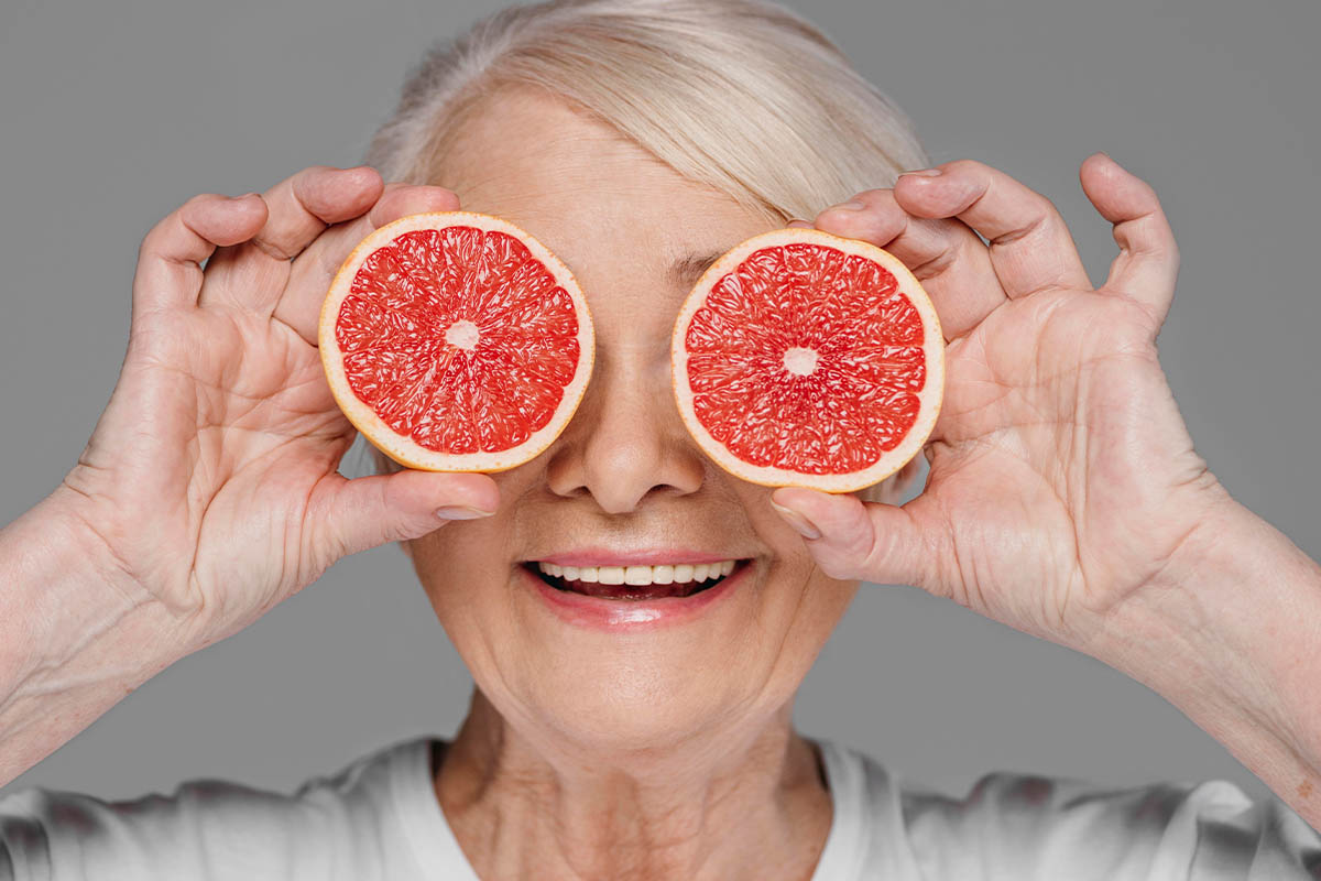 gözlerinin önünde greyfurt dilimi tutan yaşlı kadın