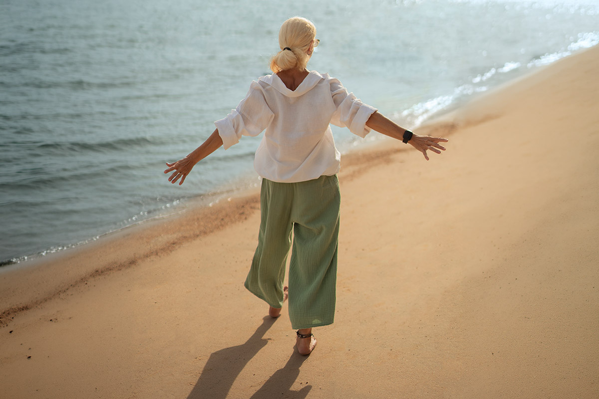 sahilde yürüyüş yapan sarı saçlı kadın