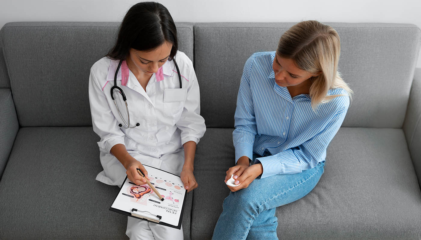 Koltukta hastasına panodaki şemayı açıklayan kadın doktor.
